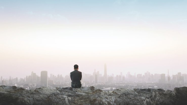 Businessmen look at the city from the outskirts.