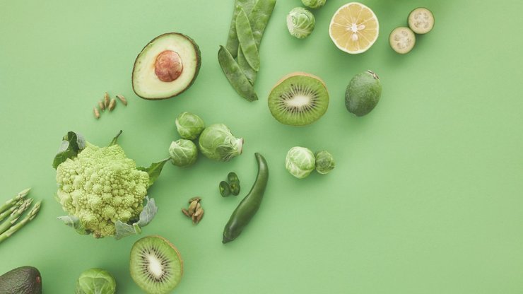 Slices of Fruits Beside Green Vegetables