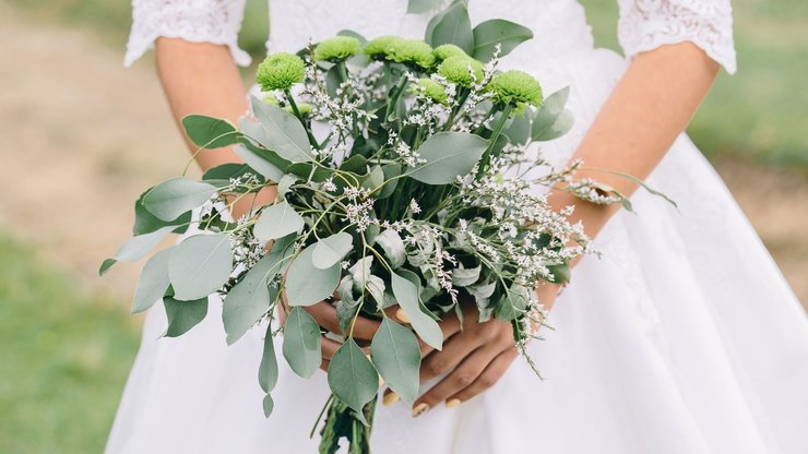 beautiful green wedding bouquet with eucalyptus in bride hands, close up