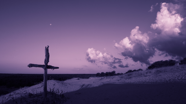 Purple landscape with wooden Cross or crucifix.  Concept for Lent Season, Holy Week, Palm Sunday and Good Friday. Late evening.