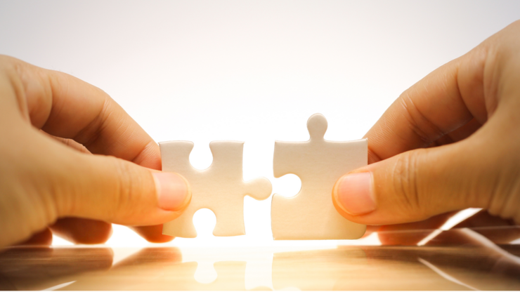 Woman's hand holding and connecting jigsaw puzzles. Business solutions, connection, achievement, and strategy concept