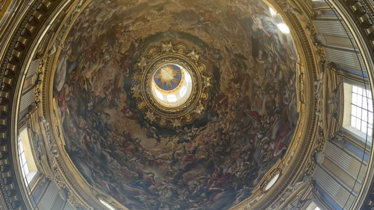 The image was taken at Sant'Agnese in Agone in Rome, featuring the dome of a 17th-century Baroque church, with the Dove of the Holy Spirit as the focal point among various biblical figures and events.
