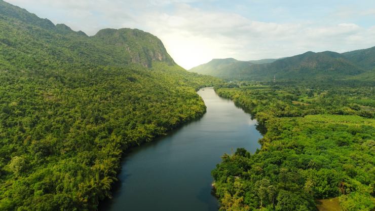 Beautiful natural scenery of river in southeast Asia tropical green forest  with mountains in background, aerial view drone shot