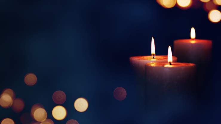 Candle lights in blue darkness with golden bokeh for solemn moments
