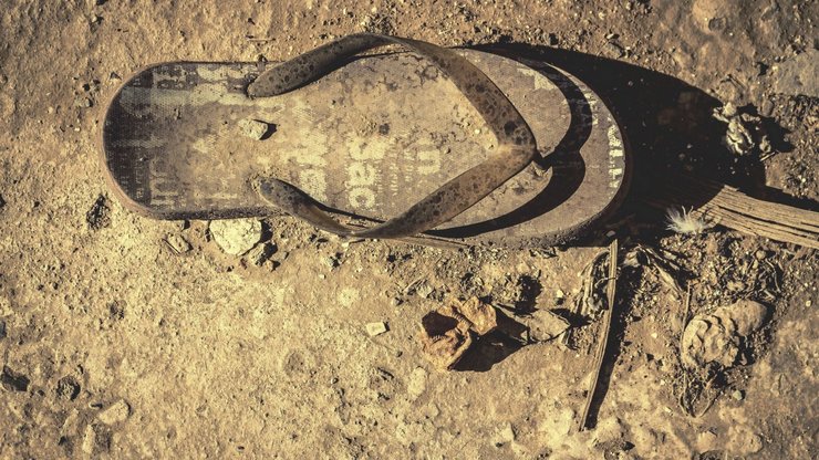 an old rusty slipper laying on the ground.